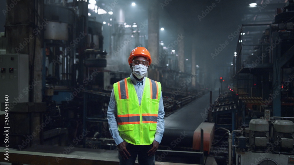 Masked supervisor looking camera at digital energy production factory.