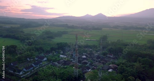 cellular antenna in the middle of the countryside with a view of four mountains (Telomoyo, Andong, Merbabu and Merapi). volcano in sunrise sky. latest information technology photo