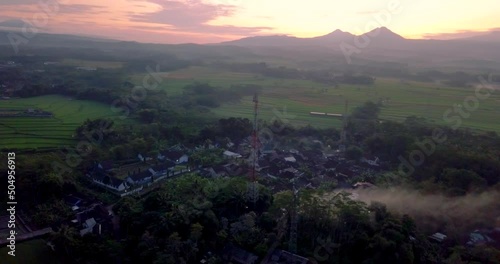 cellular antenna in the middle of the countryside with view of four mountains (telomoyo, andong, merbabu and merapi). volcano in sunrise sky. latest information technology photo