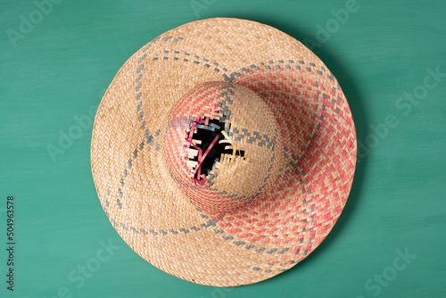 Sombrero de paja de mujer roto sobre fondo verde. Campestre y de picnic photo