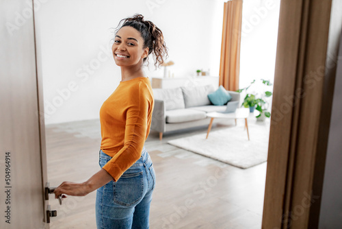 Cheerful African American Female Opening Door Entering Her Home