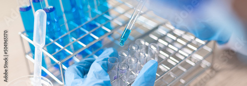 Scientists are carrying blue chemical test tubes to prepare for the determination of chemical composition and biological mass in a scientific laboratory, Scientists and research in the lab Concept.