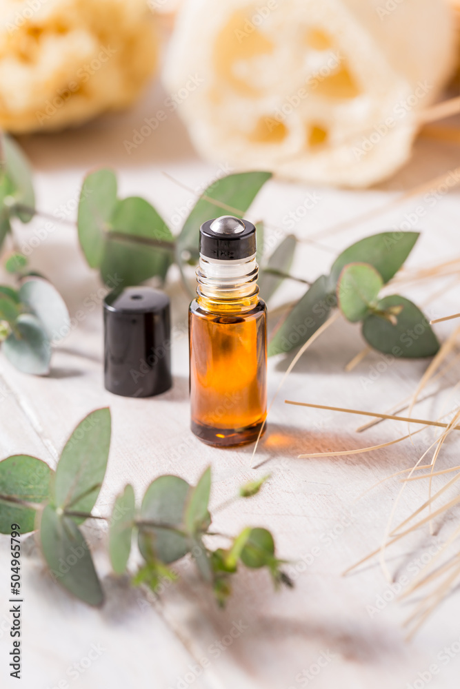 Natural handmade cosmetics - bottle with essential oil stick with eucalyptus branch