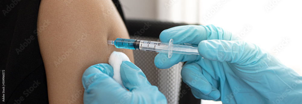 Doctor is vaccinating women with antibiotics or new antibodies to prevent the spread of the virus, Vaccination against communicable diseases concept. Doctor is vaccinating women with antibiotics or new antibodies to prevent the spread of the virus, Vaccination against communicable diseases concept.