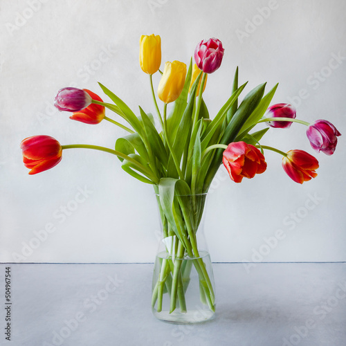 A bouquet of colorful tulips in a glass vase.