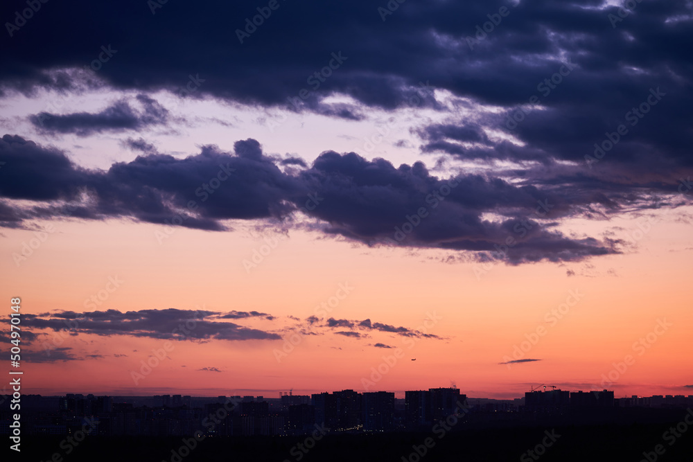 Dark clouds in the evening sunset sky with the setting sun. Dramatic sky during orange sunset Dark clouds in the evening sunset sky with the setting sun. Dramatic sky during orange sunset