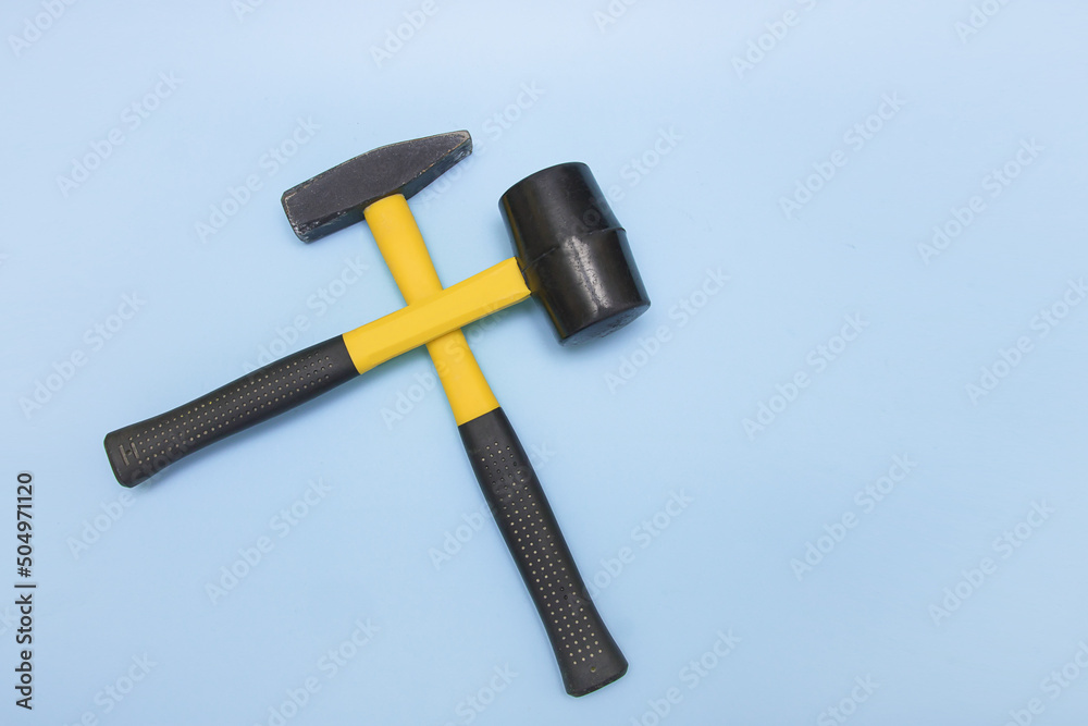 hammer and mallet on a light blue background crosswise hammer and mallet on a light blue background crosswise