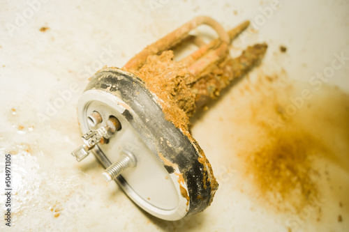 Old tubular electric heater that has worked inside a household boiler for ten years without maintenance and cleaning. Corrosion, rust and mineral deposits on the heating element. Repair boiler