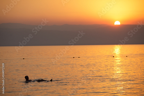 Man floating in the dead sea at sunset  Jordan