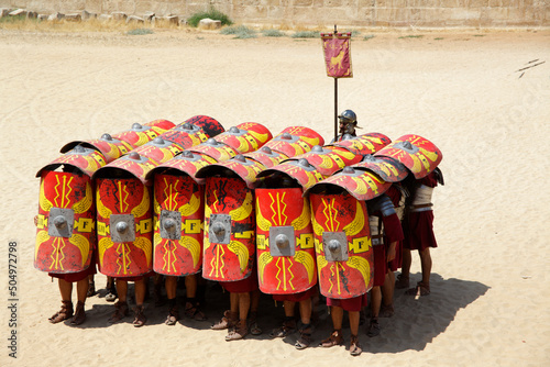 Fototapeta Actors playing roman legionaries soldiers in the tortoise tactic, Jerash, Jordan