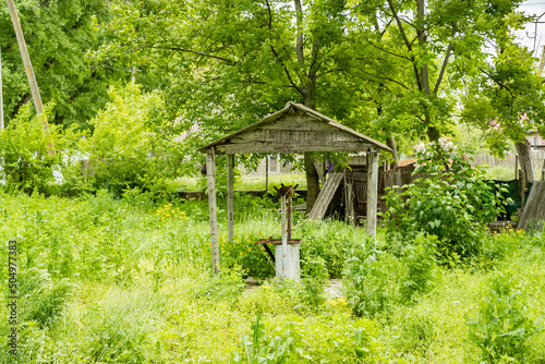 An old well overgrown with grass. The well for water intake is located in the countryside.