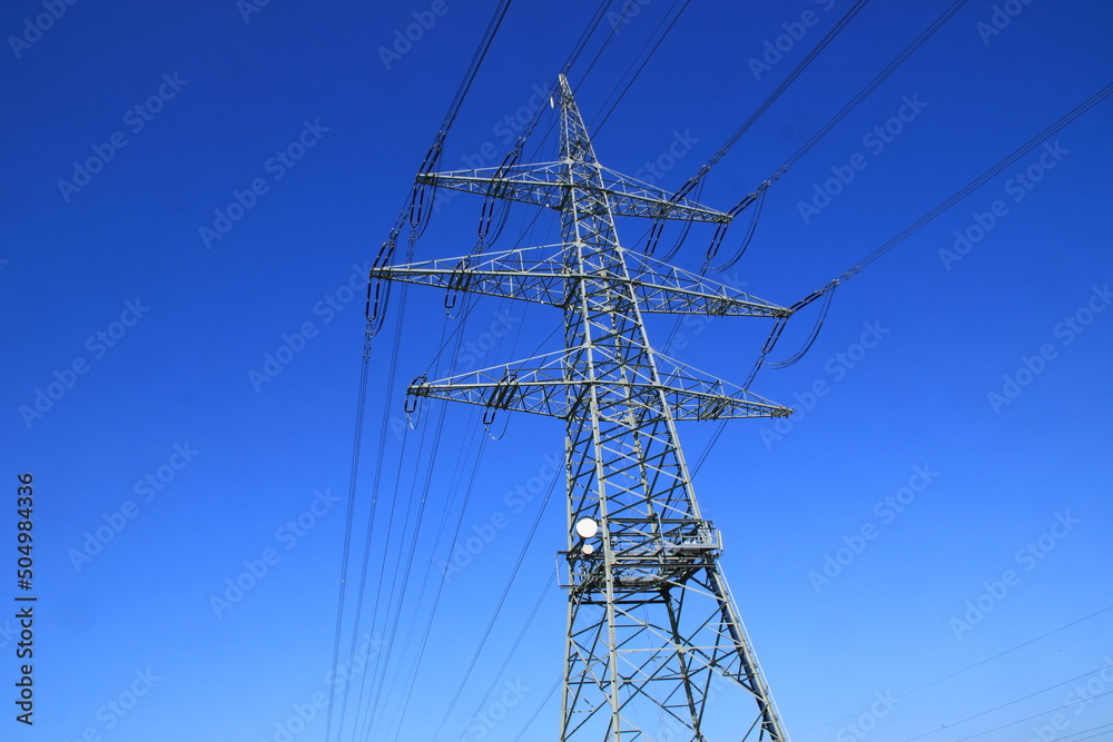 Einzelner Hochspannungsmast vor einem blauen Himmel Einzelner Hochspannungsmast vor einem blauen Himmel