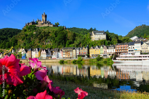 Picturesque town of Cochem, Germany with flowers, castle and early morning reflections in the Moselle River