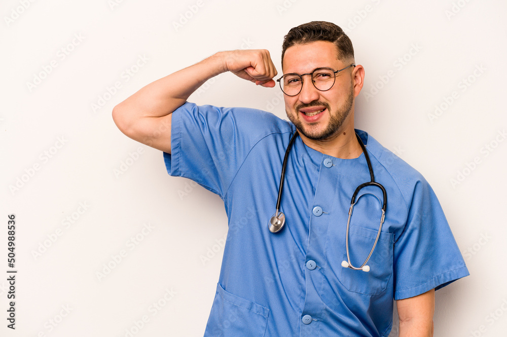 Hispanic nurse man isolated on white background raising fist after a victory, winner concept. Hispanic nurse man isolated on white background raising fist after a victory, winner concept.