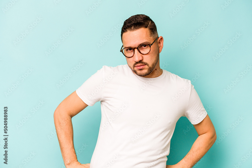 Young hispanic man isolated on blue background confused, feels doubtful and unsure. Young hispanic man isolated on blue background confused, feels doubtful and unsure.