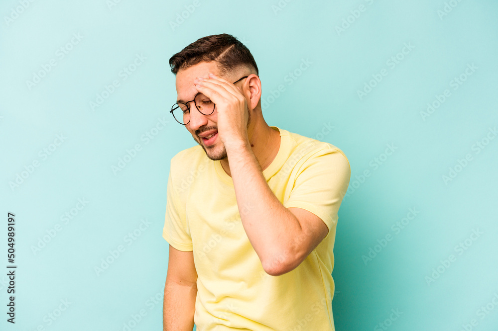 Young hispanic man isolated on blue background joyful laughing a lot. Happiness concept.