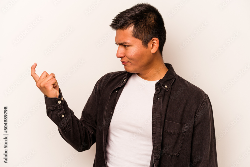 Young hispanic man isolated on white background pointing with finger at you as if inviting come closer. Young hispanic man isolated on white background pointing with finger at you as if inviting come closer.