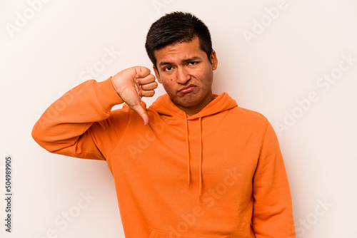 Young hispanic man isolated on white background showing thumb down and expressing dislike.