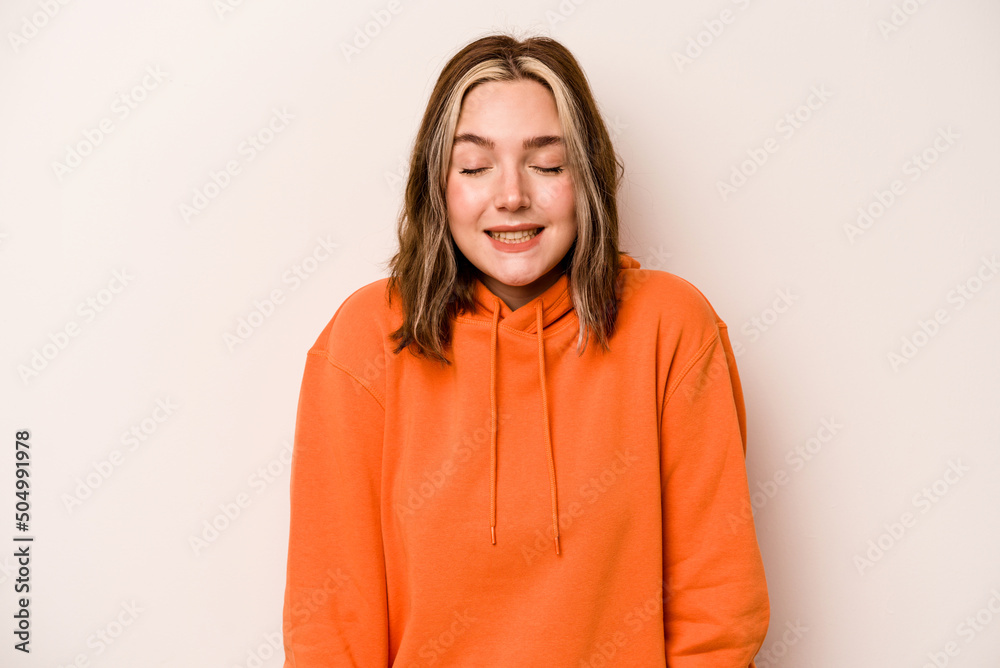 Young caucasian woman isolated on white background laughs and closes eyes, feels relaxed and happy. Young caucasian woman isolated on white background laughs and closes eyes, feels relaxed and happy.