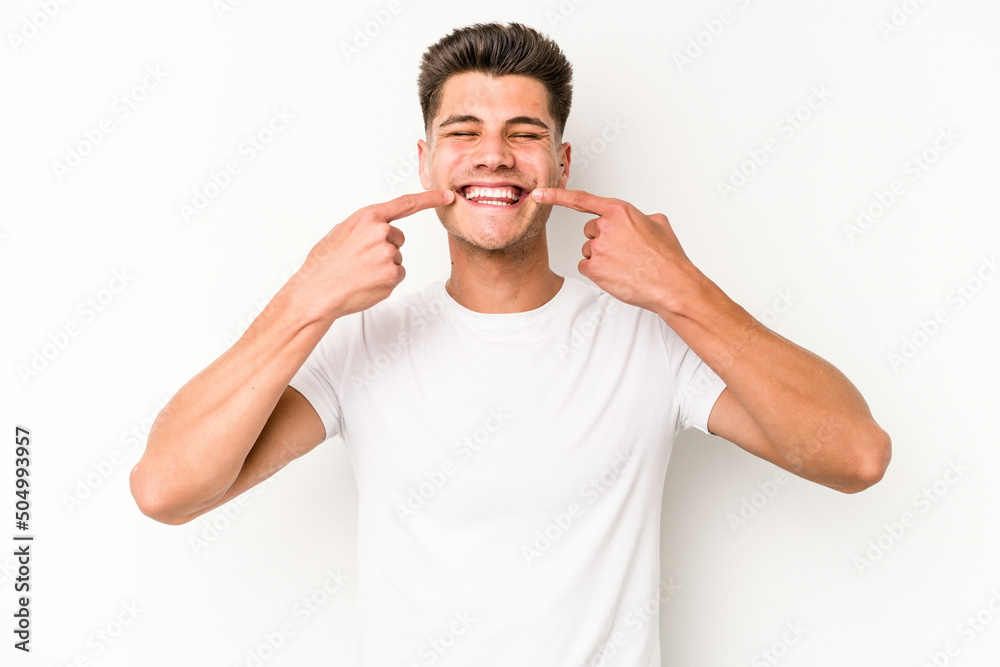 Young caucasian man isolated on white background smiles, pointing fingers at mouth. Young caucasian man isolated on white background smiles, pointing fingers at mouth.