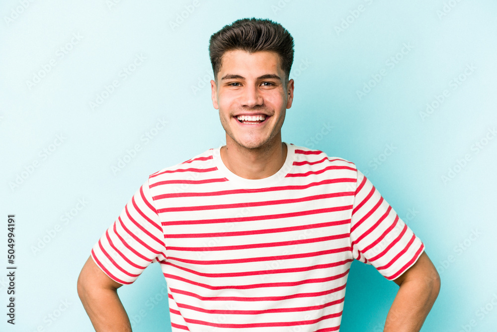 Young caucasian man isolated on blue background confident keeping hands on hips. Young caucasian man isolated on blue background confident keeping hands on hips.
