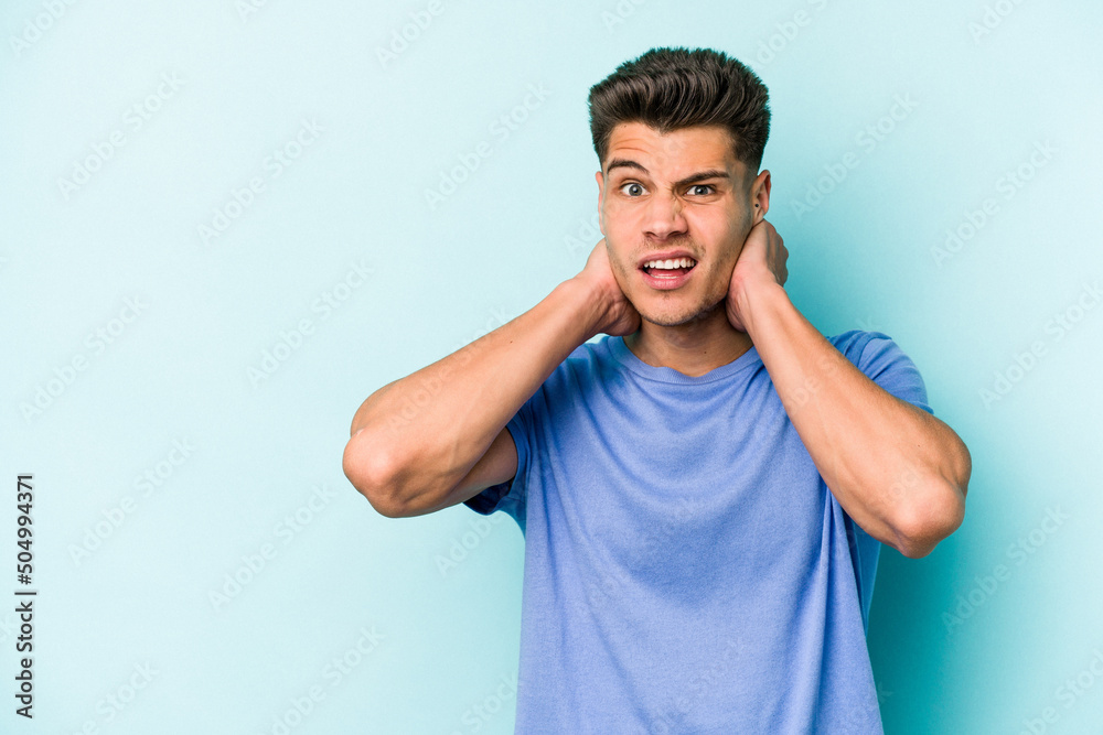 Young caucasian man isolated on blue background touching back of head, thinking and making a choice. Young caucasian man isolated on blue background touching back of head, thinking and making a choice.