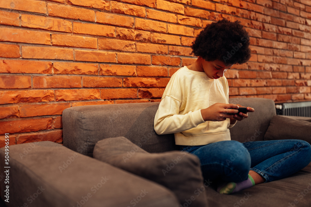 African american teen playing games on smartphone African american teen playing games on smartphone