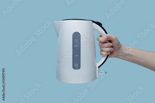 girl holding an electric kettle on a blue background.