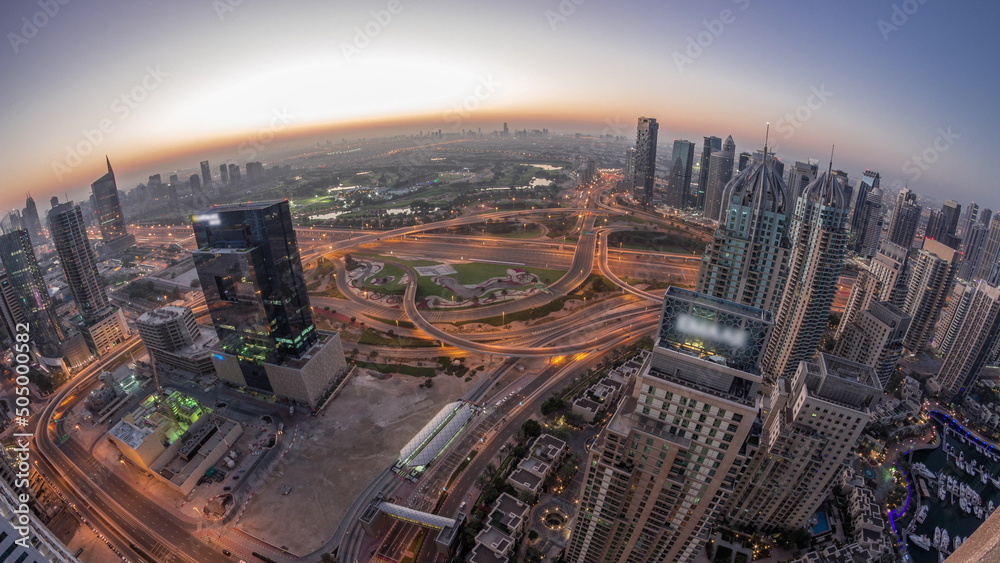 Dubai marina and JLT skyscrapers along Sheikh Zayed Road aerial night to day timelapse.