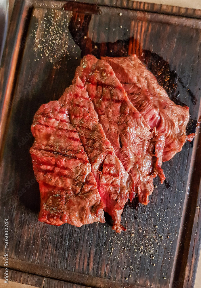 Roast beef steak of medium roast on a wooden board.