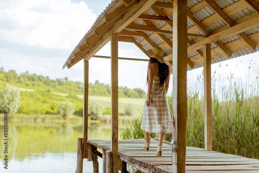 Φωτογραφία Young woman walking on the wooden pier at the calm lake