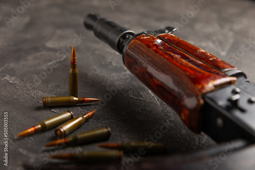 Bullets and ammo magazine with kolashnikov assault rifle on black texture marble.Composition with place for text.Rifle and carbine cartridges on wooden background.Military concept.Copy space
