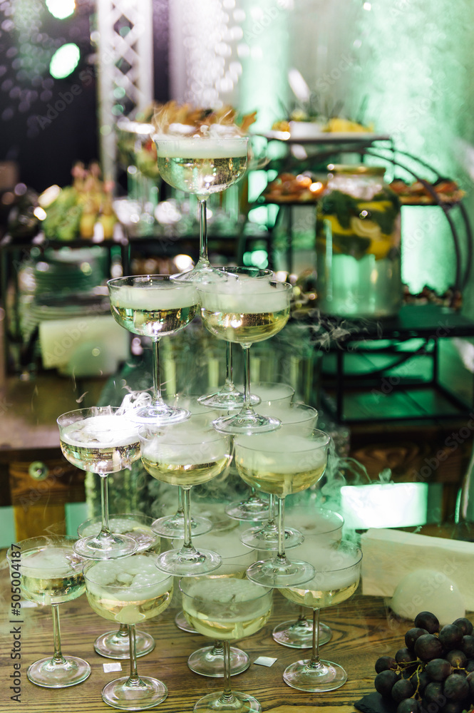 Champagne glasses standing in a tower at the party