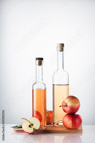 Bottled apple cider vinegar and fresh apples.