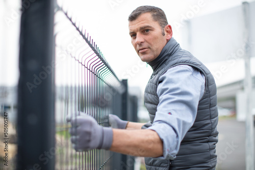 Foto man working on a fence