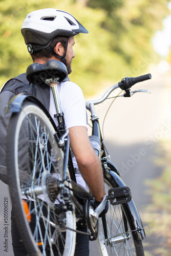 portrait of man carrying a bike