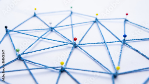 Netzwerk aus Stecknadeln und Faden mit vielen Verbindungen
