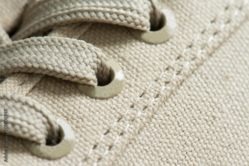 Lacing of textile sneakers close-up. New sport shoe laced up, side view. Elastic shoes of modern mesh fabric trainers for fitness, sport exercises and active lifestyle.