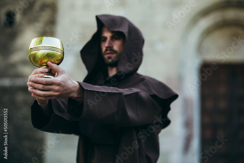 The Monk holds the holy grail in his hand.