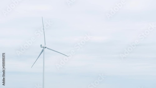 Aerial view of wind turbines standing in the field generating clean renewable energy