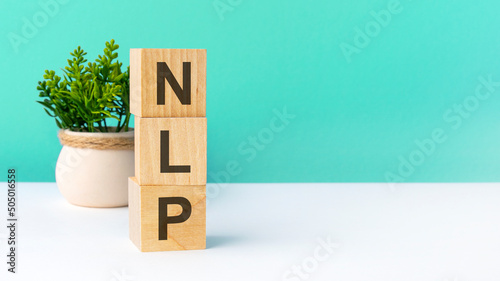 nlp - word from wooden blocks with letters, green background. copy space available photo
