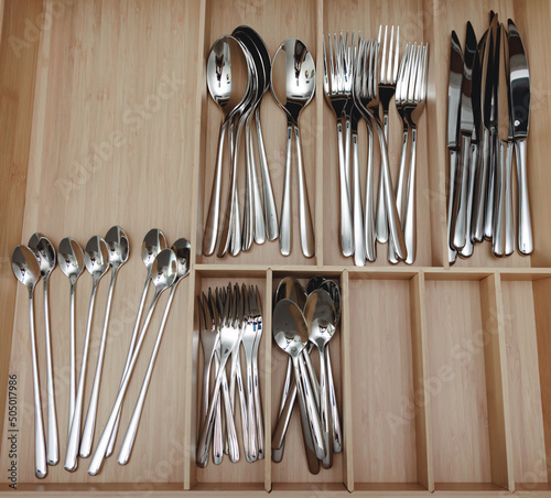 steel gray stylish modern spoons, forks, knives, service, kitchen set on the shelf of the store, sales, market, design, gift, shopping center. Black Friday, new year.