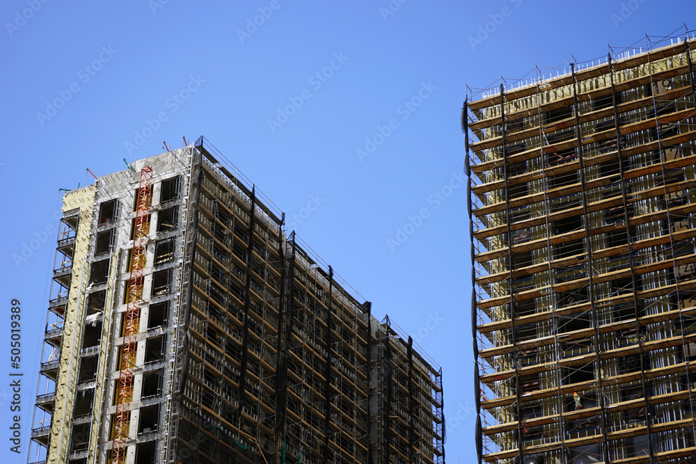 Residential building under construction against the blue sky. Housing construction. Construction site.