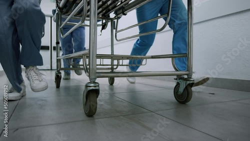 Medics legs running down hospital corridor rolling gurney to emergency room. photo