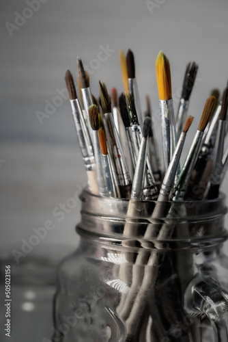 Group of old used paintbrushes in jar,soft focus and shallow depth of field composition.
