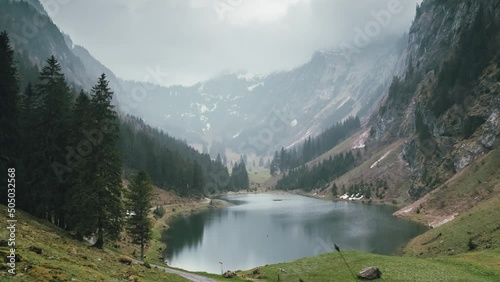 Fairytale lake surrounded by huge mountains in the Swiss alps on a cloudy day