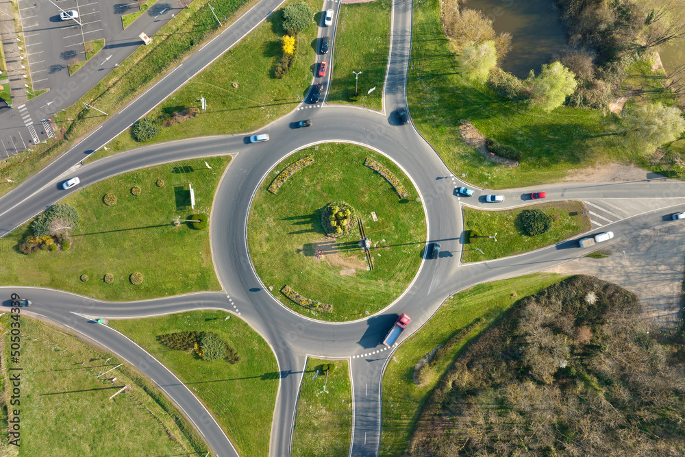 Aerial view of road roundabout intersection with moving heavy traffic. Urban circular transportation crossroads Aerial view of road roundabout intersection with moving heavy traffic. Urban circular transportation crossroads