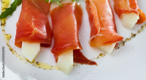 Close-up of sliced jamon with fresh juicy melon - national dish of Spanish cuisine