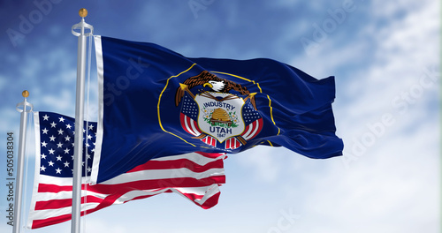 The Utah state flag waving along with the national flag of the United States of America