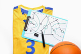 Clipboard with drawn scheme of basketball game and uniform on white background